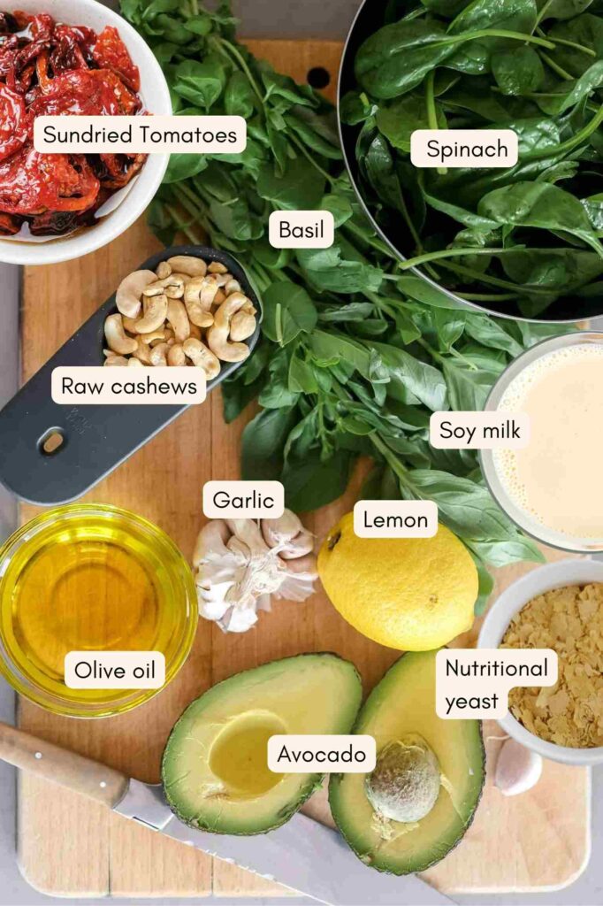 Infographic of the ingredients to make vegan avocado pasta on a wooden chopping board with written labels.